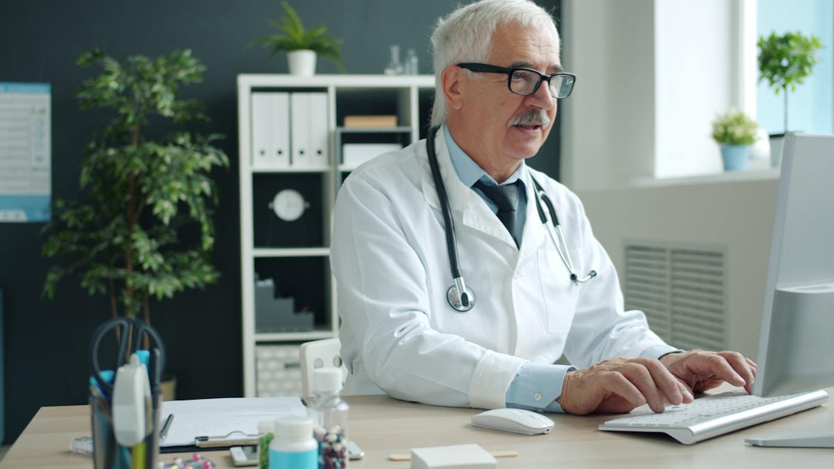 Doctor working on telehealth platform at his desk